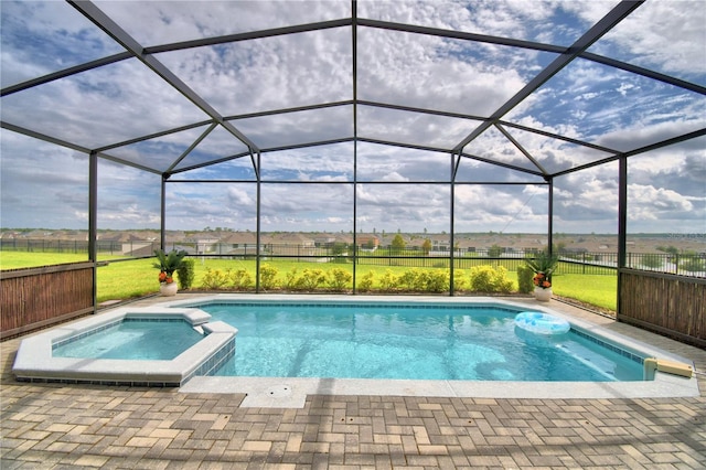 view of swimming pool featuring a patio, an in ground hot tub, and a lanai