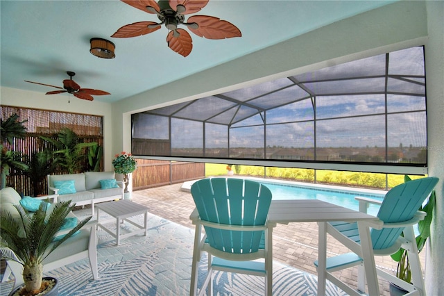 view of patio with glass enclosure, ceiling fan, and an outdoor living space