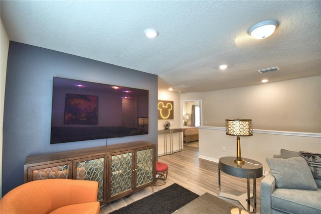 living room with hardwood / wood-style flooring and a textured ceiling