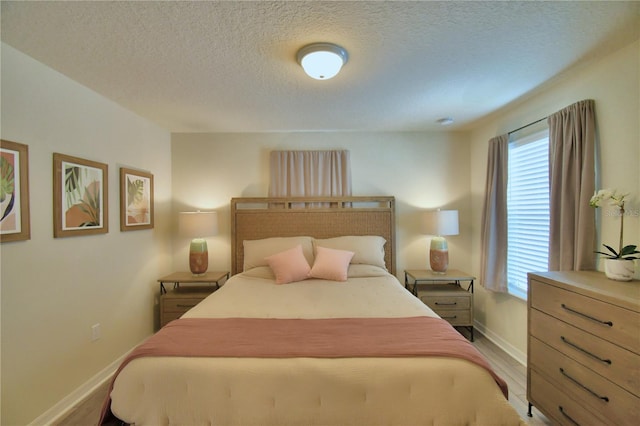 bedroom featuring light wood-type flooring and a textured ceiling