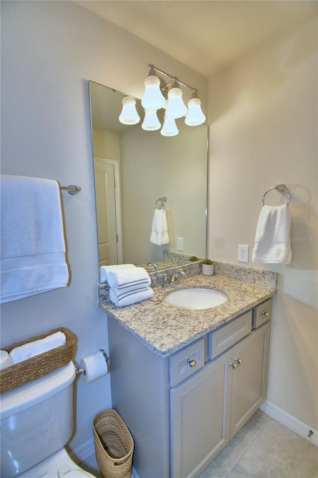 bathroom featuring vanity, tile patterned flooring, and toilet