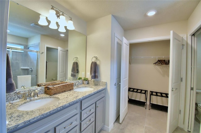 bathroom featuring tile patterned flooring, walk in shower, vanity, and toilet