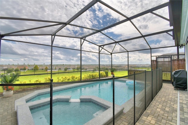 view of pool featuring a grill, an in ground hot tub, a lanai, and a patio area