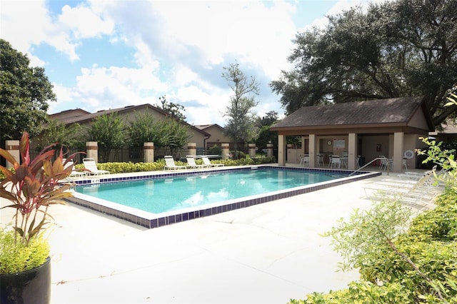 view of swimming pool featuring a patio area and an outdoor structure