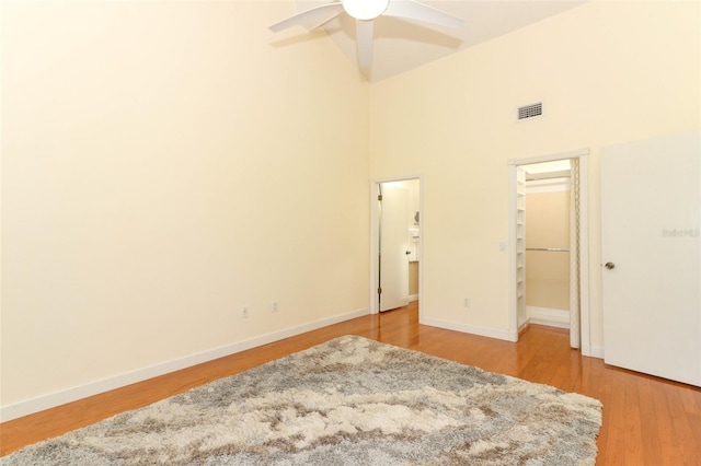 unfurnished bedroom featuring a high ceiling, light wood-type flooring, and ceiling fan