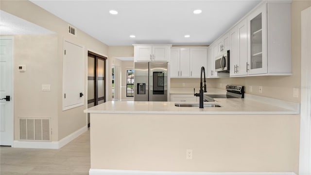 7972 Snowberry Cir, Orlando, FL 32819 - kitchen featuring visible vents, stainless steel appliances, glass insert cabinets, and a sink