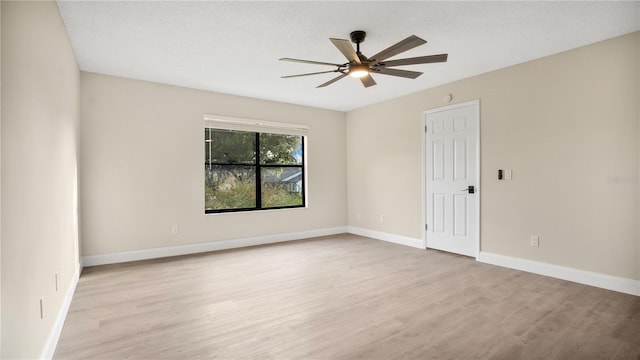 empty room with ceiling fan, a textured ceiling, and light wood-type flooring