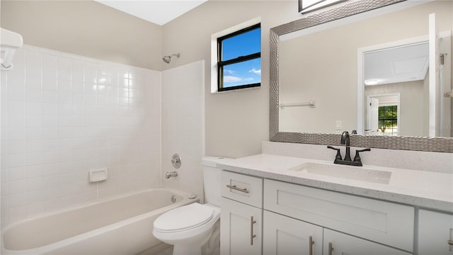 full bathroom featuring a healthy amount of sunlight, vanity, toilet, and tiled shower / bath