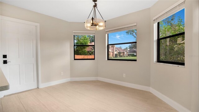 7972 Snowberry Cir, Orlando, FL 32819 - spare room with a chandelier, light wood-type flooring, plenty of natural light, and baseboards
