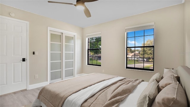 7972 Snowberry Cir, Orlando, FL 32819 - bedroom featuring a ceiling fan, light wood-style flooring, and baseboards