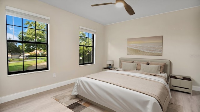 7972 Snowberry Cir, Orlando, FL 32819 - bedroom featuring baseboards, light wood-type flooring, and a ceiling fan