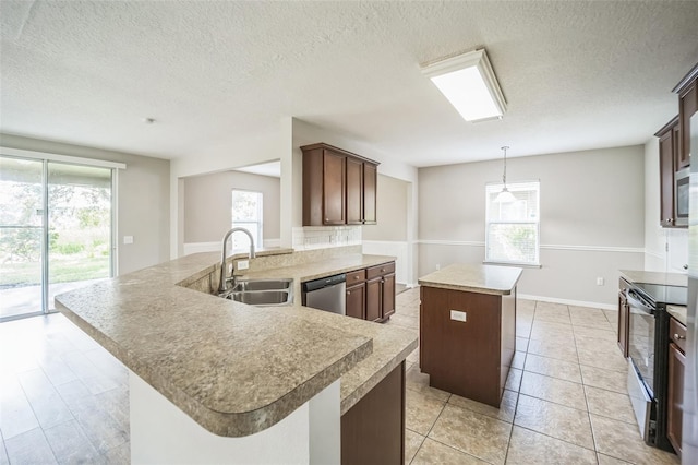 kitchen featuring a healthy amount of sunlight, sink, an island with sink, and stainless steel appliances