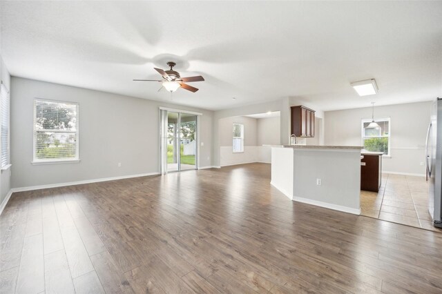 unfurnished living room with ceiling fan and dark hardwood / wood-style floors