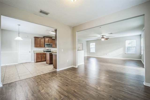 kitchen with electric range, light hardwood / wood-style floors, ceiling fan, and pendant lighting