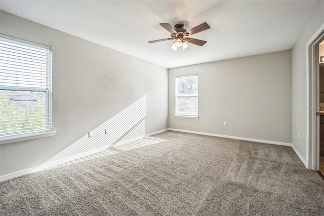 spare room featuring a healthy amount of sunlight, carpet flooring, and ceiling fan