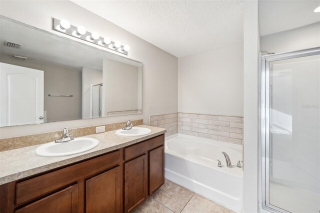 bathroom featuring vanity, a textured ceiling, tile patterned floors, and separate shower and tub