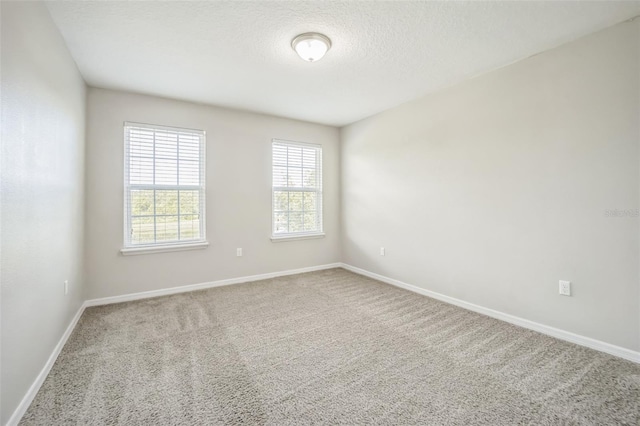 carpeted spare room with a textured ceiling