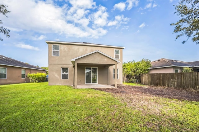 back of house featuring a lawn and a patio area