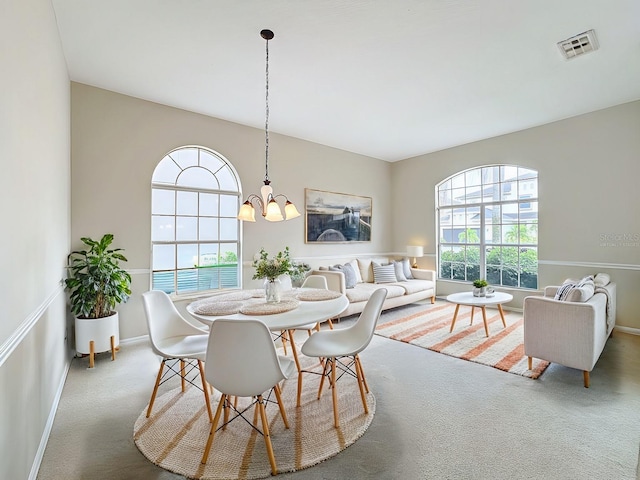 carpeted dining space featuring an inviting chandelier