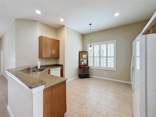 kitchen with white appliances, sink, a textured ceiling, decorative light fixtures, and kitchen peninsula