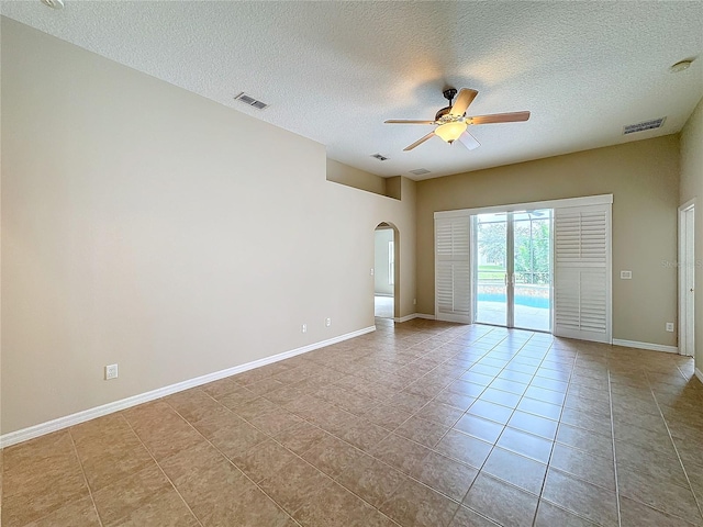 tiled empty room featuring a textured ceiling and ceiling fan