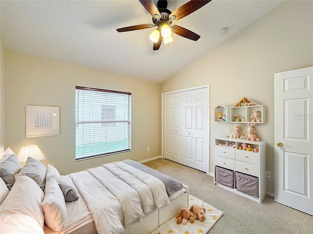 bedroom with ceiling fan, a closet, light colored carpet, and lofted ceiling