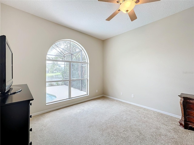 interior space with light carpet, a textured ceiling, and ceiling fan