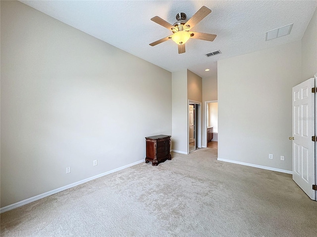 empty room featuring light carpet, a textured ceiling, and ceiling fan