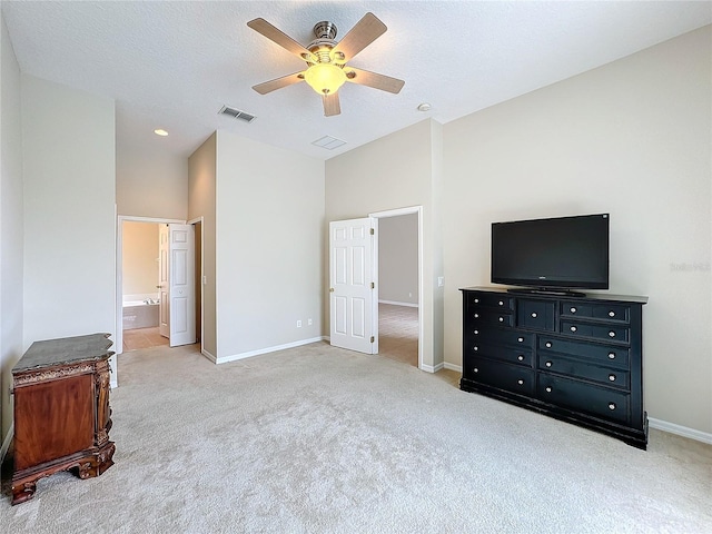 bedroom with ensuite bathroom, ceiling fan, light colored carpet, and a textured ceiling