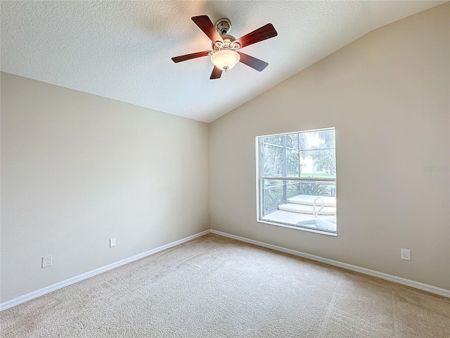 carpeted empty room with a textured ceiling, ceiling fan, and vaulted ceiling