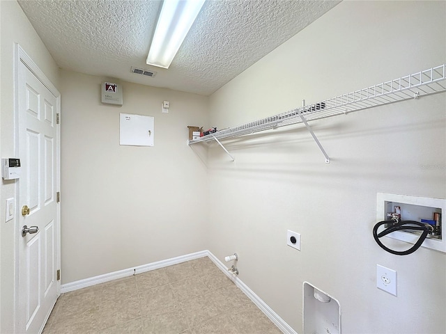 laundry area featuring electric dryer hookup, gas dryer hookup, a textured ceiling, and hookup for a washing machine