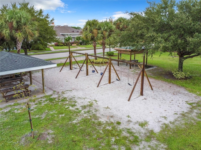 view of home's community featuring a playground and a yard