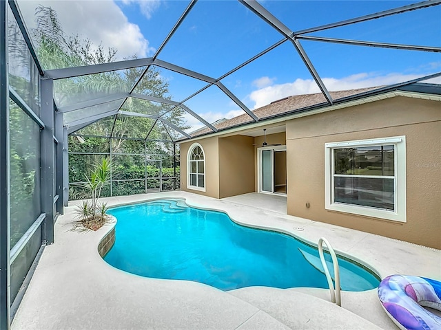 view of pool with glass enclosure, ceiling fan, and a patio