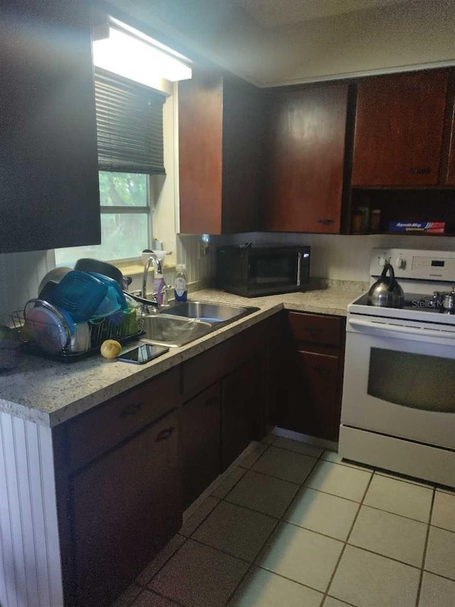 108 5th Jpv St, Winter Haven, FL 33880 - kitchen featuring white electric range, a sink, black microwave, light tile patterned flooring, and light countertops