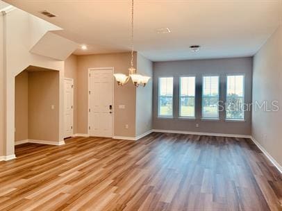 interior space featuring wood-type flooring and a chandelier