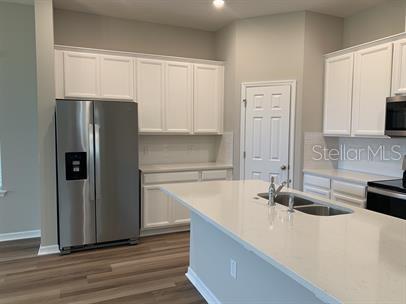 kitchen featuring white cabinets, sink, backsplash, appliances with stainless steel finishes, and dark hardwood / wood-style flooring