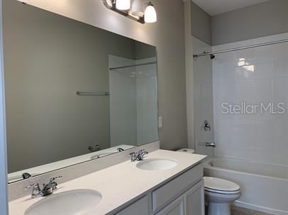 full bathroom featuring tub / shower combination, vanity, and toilet