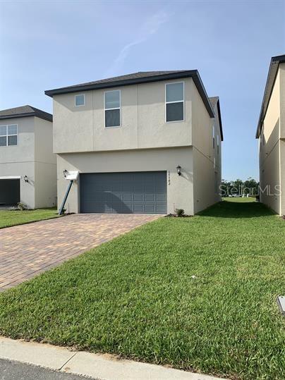 view of property with a garage and a front lawn