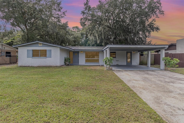 view of front facade featuring a lawn and a carport