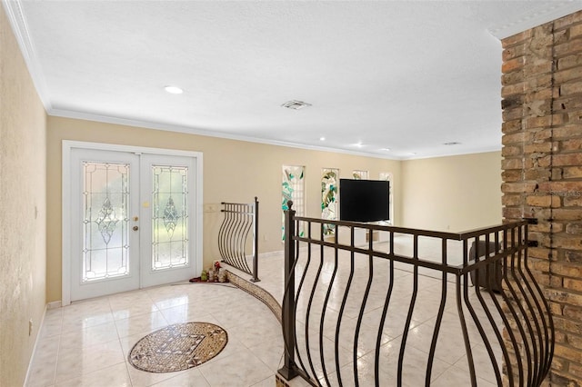 tiled foyer entrance featuring a textured ceiling, french doors, and crown molding