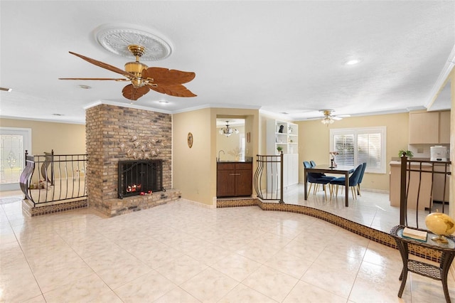 tiled living room with a textured ceiling, ceiling fan with notable chandelier, ornamental molding, and a brick fireplace