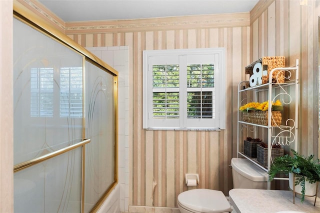 full bathroom with bath / shower combo with glass door, vanity, crown molding, and toilet