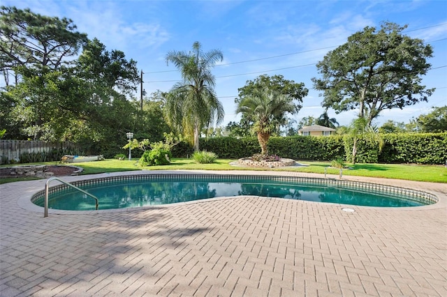 view of pool with a patio area and a yard