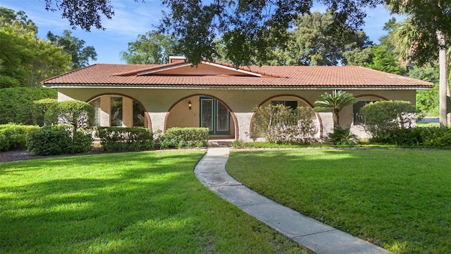 mediterranean / spanish home with a front yard