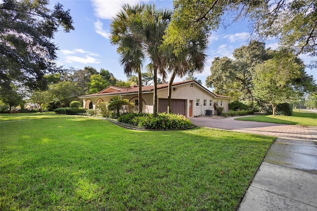 view of property exterior with a lawn, central AC unit, and a garage