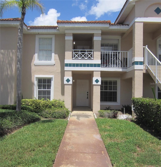 view of front facade featuring a balcony and a front lawn