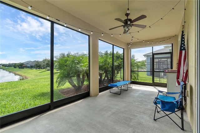 unfurnished sunroom with a water view and ceiling fan