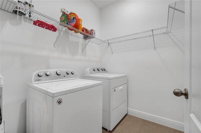 laundry area with washer and dryer and light tile patterned floors