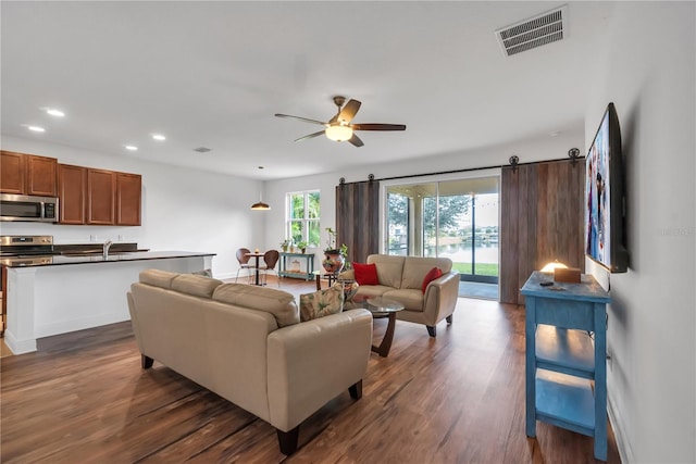 living room featuring sink, dark wood-type flooring, and ceiling fan