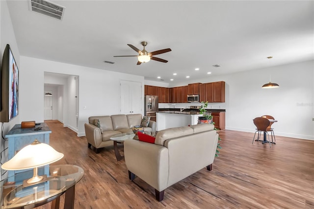 living room with wood-type flooring and ceiling fan